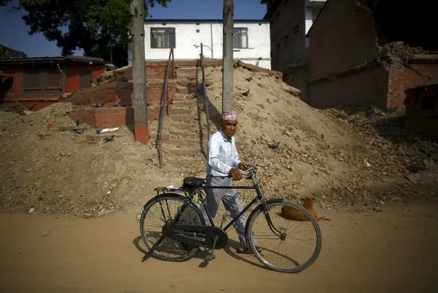 A man walks past a collapsed temple after the earthquake in Kathmandu May 14, 2015. (Photo by Navesh Chitrakar/Reuters)
