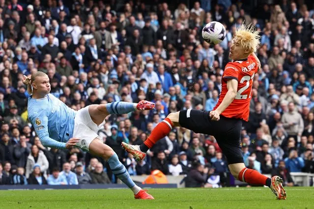 Manchester City's Norwegian striker #09 Erling Haaland (L) sees his shot deflected into the net by Luton Town's Japanese defender #27 Daiki Hashioka (R) for an own-goal during the English Premier League football match between Manchester City and Luton Town at the Etihad Stadium in Manchester, north west England, on April 13, 2024. (Photo by Darren Staples/AFP Photo)