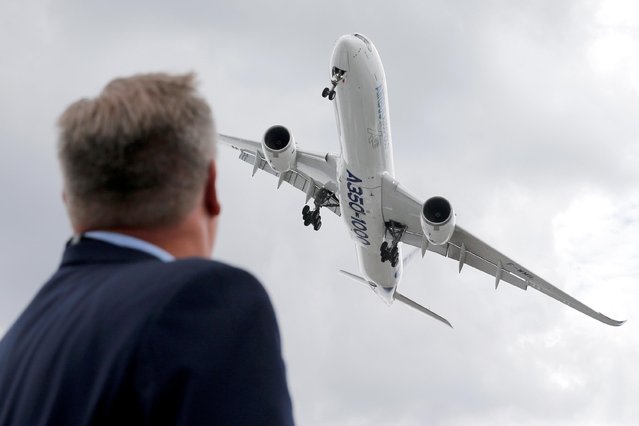 A visitor looks at an Airbus A350-1000 as he performs during the 53rd International Paris Air Show at Le Bourget Airport near Paris, France on June 19, 2019. (Photo by Pascal Rossignol/Reuters)