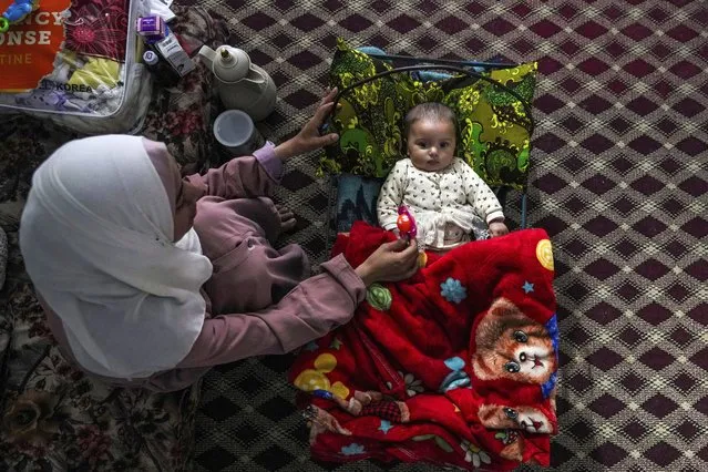 Rola Saqer sits beside her baby Masa Mohammad Zaqout in Zawaida, central Gaza, April 4, 2024. Zaqout was born Oct. 7, the day the Israel-Hamas war erupted. Mothers who gave birth in the Gaza Strip that day fret that their 6-month-old babies have known nothing but brutal war, characterized by a lack of baby food, unsanitary shelter conditions and the crashing of airstrikes. (Photo by Abdel Kareem Hana/AP Photo)
