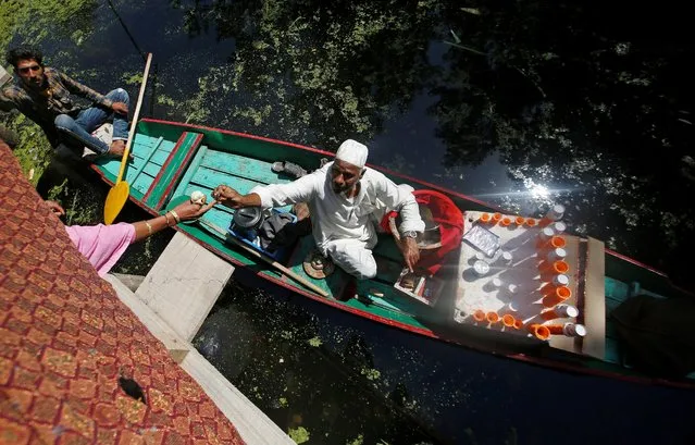 A vendor sitting on a boat sells ice cream at Dal Lake in Srinagar, June 27, 2019. (Photo by Danish Ismail/Reuters)