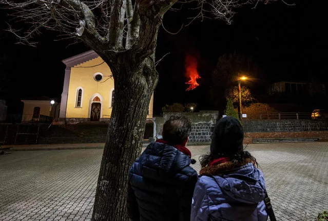 This photo taken late on February 24, 2021 in Zafferana Etnea, Sicily, shows watching lava flowing along the sides of the southern crater of the Etna volcano as a new eruptive episode of tall lava fountains, known as paroxysm, occurs. (Photo by Giovanni Isolino/AFP Photo)