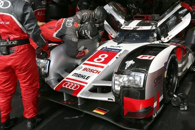 Mechanics repair the Audi R18 E-TRON Quattro No8 of driven by Lucas Di Grassi of Brazil, Loic Duval of France and Britain's Oliver Jarvis during a stop in the pits during the 83rd 24-hour Le Mans endurance race, in Le Mans, western France, Saturday, June 13, 2015. (AP Photo/David Vincent)