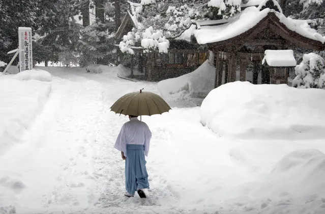 In this Saturday, May 29, 2004 file photo, a man walks near the Yahiko Shrine during snowstorm in Yahiko Mura City, Japan. (Photo by Nick Ut/AP Photo)
