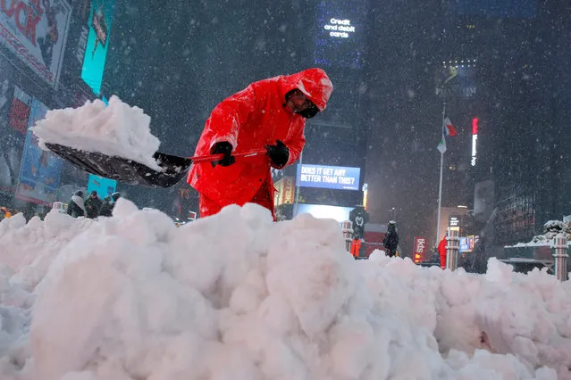 A worker clears snow in Times Square as snow falls in Manhattan, New York, U.S., March 14, 2017. (Photo by Andrew Kelly/Reuters)