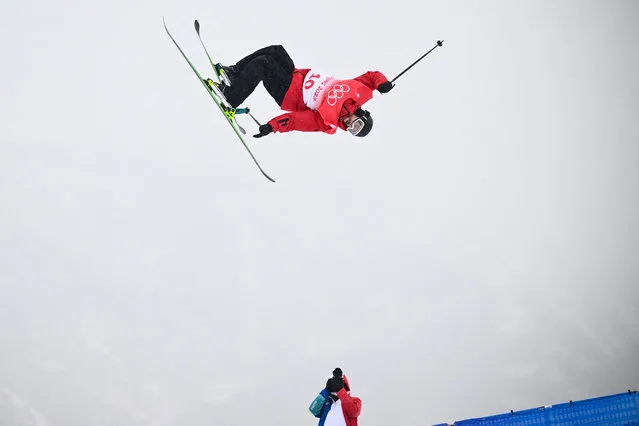 A photographer takes pictures as France's Kevin Rolland competes in the freestyle skiing men's freeski halfpipe qualification run during the Beijing 2022 Winter Olympic Games at the Genting Snow Park H & S Stadium in Zhangjiakou on February 17, 2022. (Photo by Marco Bertorello/AFP Photo)