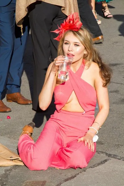 A visitor dressed in pink sips on a beverage during the Grand National Festival at Aintree Racecourse on April 7, 2017 in Liverpool, England. (Photo by Alamy Stock Photos)