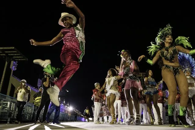 Dancers perform on the 'Samba walkway' at the Carnival Samba School during a celebration to start the traditional festivities, in Rio de Janeiro, Brazil, 24 February 2022. The event was held to present the new lighting for the next parades, which takes place this year between 20-30 April due to the Covid-19 pandemic. (Photo by Antonio Lacerda/EPA/EFE)