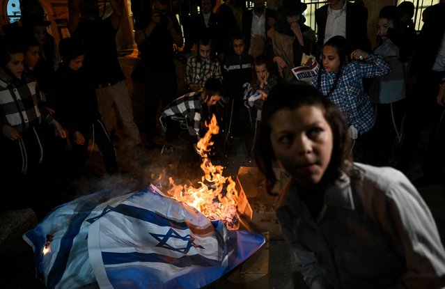 Members of the anti-Zionist Hassidic Jews group, Neturei Karta, burn Israeli flags during a rally against the creation of the state of Israel in Jerusalem's Mea Shearim neighbourhood on May 14, 2024, as the country marks the 76th anniversary of its creation. (Photo by Ronaldo Schemidt/AFP Photo)
