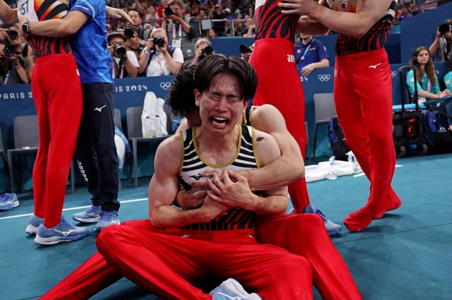 Kazuma Kaya of Team Japan is embraced by a teammate as they celebrate winning the gold medal during the Artistic Gymnastics Men's Team Final on day three of the Olympic Games Paris 2024 at Bercy Arena on July 29, 2024 in Paris, France. (Photo by Amanda Perobelli/Reuters)