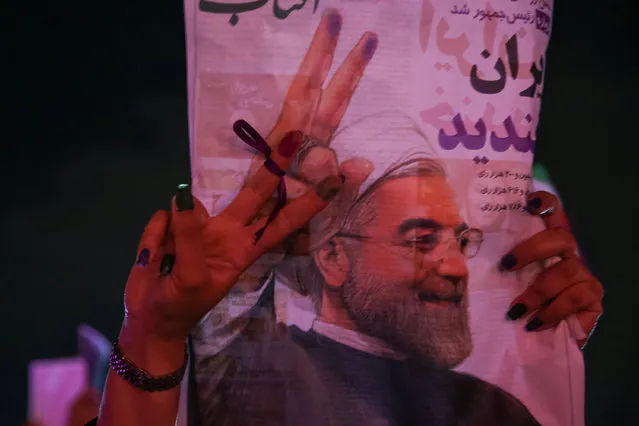 A supporter of Iranian president Hassan Rouhani holds his poster as she celebrates his victory in the presidential election, in Tehran, Iran, May 20, 2017. (Photo by Reuters/TIMA)