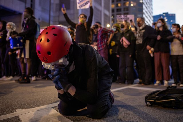 An anarchist kneels in prayer as pro-Palestinian protesters are kettled by police outside the Israeli consulate, on the sidelines of the Democratic National Convention (DNC), in Chicago on August 21, 2024. (Photo by Adrees Latif/Reuters)