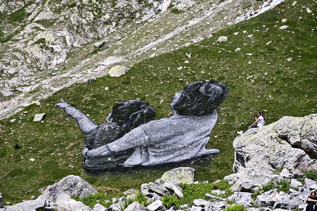 A general view of a giant artwork entitled “La Grand Dame” by French land artist Saype, painted on the slopes of the Mont Blanc massif, the highest mountain in the Alps, in Courmayeur, Italy, on July 3, 2023. The eco friendly monumental fresco, made with natural and biodegradable charcoal, chalk and milk protein, will disappear as the grass grows. (Photo by Piero Cruciatti/Anadolu Agency via Getty Images)