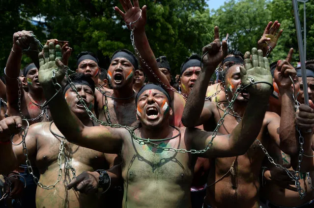 Indian supporters of Gorkhaland chant slogans tied with chains during a protest march in capital New Delhi on July 23, 2017. Eastern India's hill resort of Darjeeling has been rattled at the height of tourist season after violent clashes broke out between police and hundreds of protesters of the Gorkha Janmukti Morcha (GJM) -- a long-simmering separatist movement that has long called for a separate state for ethnic Gorkhas in West Bengal. The GJM wants a new, separate state of “Gorkhaland” carved out of eastern West Bengal state, of which Darjeeling is a part. (Photo by Sajjad Hussain/AFP Photo)