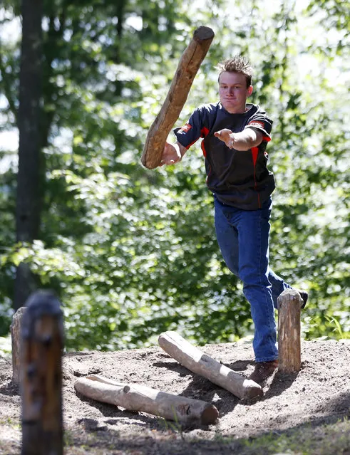 In this July 10, 2014 photo, Stephen Nowack of Bethesda, Md., takes part in the pulp toss event during a team relay event at the Adirondack Woodsmen's School at Paul Smith's College in Paul Smiths, N.Y. Eighteen young students in matching gray sports shirts took part recently in a weeklong crash course on old-school lumberjack skills such as sawing, chopping, ax throwing, log boom running and pole climbing. (Photo by Mike Groll/AP Photo)