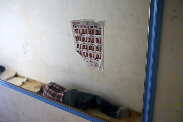 A sleeping migrant is reflected in a mirror where a poster of the Hellenic Red Cross is seen sticked at a deserted hotel where migrants found shelter at the Greek island of Kos, August 13, 2015. (Photo by Alkis Konstantinidis/Reuters)