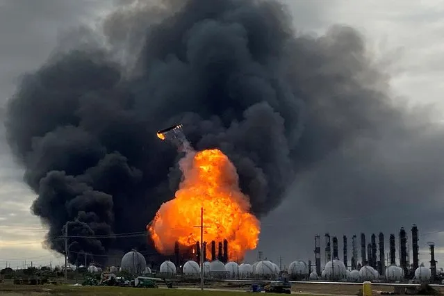 A process tower flies through air after exploding at the TPC Group Petrochemical Plant, after an earlier massive explosion sparked a blaze at the plant in Port Neches, Texas, November 27, 2019. Three workers were injured and 60,000 residents of four towns were told to evacuate after early morning explosions at the plant, the latest in a series of chemical plant accidents in the region. (Photo by Erwin Seba/Reuters)