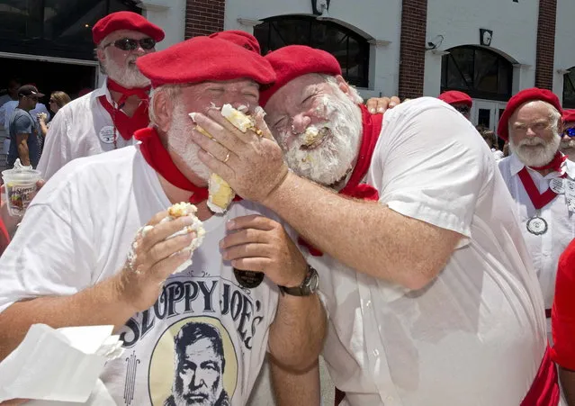 Greg Fawcett (L), has his face smeared with cake by Stephen Terry after they and past “Papa” Hemingway look-alike contest winners sand “Happy Birthday” to commemorate Ernest Hemingway's upcoming 115th birthday anniversary in Key West, Florida in this July 19, 2014 handout photo provided by the Florida Keys News Bureau. Key West's annual Hemingway Days festival honors the famed author who lived there in the 1930s. (Photo by Andy Newman/Reuters/Florida Keys News Bureau)