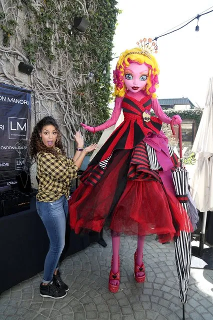 Jordin Sparks and Gooliope, the tallest Monster High character, try on fierce and fabulous jewelry at KIIS-FM's Teen Choice Gifting Suite on Fri., August 14, 2014, in Los Angeles. (Photo by Casey Rodgers/Invision for Mattel/AP Images)