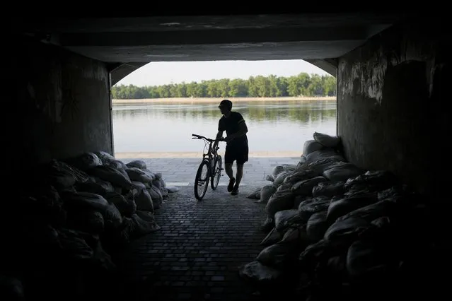 A man enters an underpass in Kyiv, Ukraine, Friday, June 10, 2022. With war raging on fronts to the east and south, the summer of 2022 is proving bitter for the Ukrainian capital, Kyiv. The sun shines but sadness and grim determination reign. (Photo by Natacha Pisarenko/AP Photo)