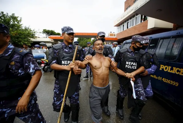 Nepalese policemen arrest a supporter of Kumar Shrestha, also known as Kumar Ghainte, after he was shot dead during what local media termed as a police encounter in Kathmandu, Nepal August 20, 2015. (Photo by Navesh Chitrakar/Reuters)