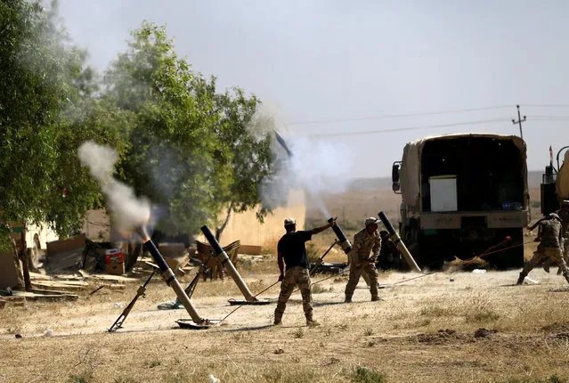 Members of Iraqi Army fire mortar shells during the war between Iraqi army and Shi'ite Popular Mobilization Forces (PMF) against the Islamic State militants in al-Ayadiya, northwest of Tal Afar, Iraq August 28, 2017. (Photo by Thaier Al-Sudani/Reuters)