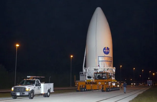 Standing atop a payload transporter on November 3, 2011, the Atlas V payload fairing containing NASA's Mars Science Laboratory spacecraft rolls down a darkened roadway during the early morning move from Kennedy Space Center's Payload Hazardous Servicing Facility to Space Launch Complex 41. (Photo by Kim Shiflett/NASA)