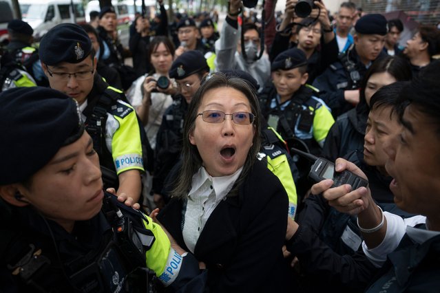 A woman is stopped by the police outside of the West Kowloon Magistrates' Court in Hong Kong, China, 19 November 2024. Out of the 47 Hong Kong pro-democracy activists arrested in 2021, 45 were sentenced in the city's largest national security trial. (Photo by Leung Man Hei/EPA/EFE)