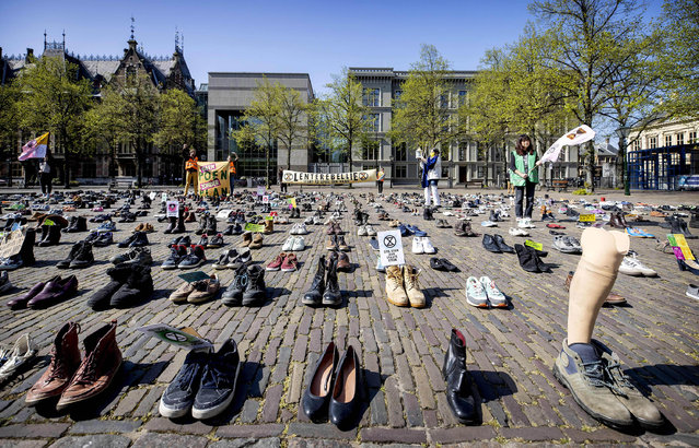 Climate activists from Extinction Rebellion call for attention to the climate, next to a collection of shoes that belong to activists who cannot demonstrate due to the spread of the coronavirus (COVID-19) on the Plein in The Hague, on April 17, 2020. (Photo by Koen Van Weel/ANP/AFP Photo)
