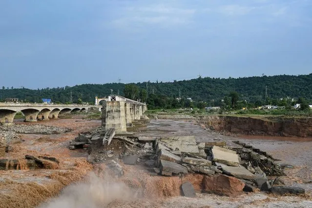 A general view of the section of a railway bridge washed away by the deluge at the Chakki River after flash floods in Kangra district, in India's Himachal Pradesh state on August 20, 2022. At least 15 people were killed in India after heavy monsoon rains triggered flash floods and landslides near the Himalayan foothills, authorities said August 20, 2022. (Photo by AFP Photo/Stringer)