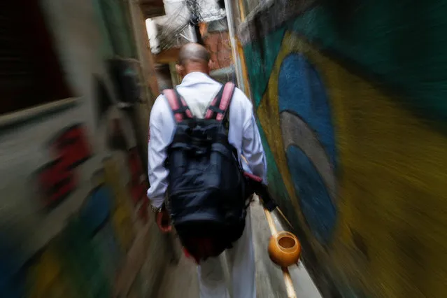 Manoel Pereira Costa, known as “Master Manel”, walks in the Rocinha favela in Rio de Janeiro, Brazil, July 25, 2016. (Photo by Bruno Kelly/Reuters)