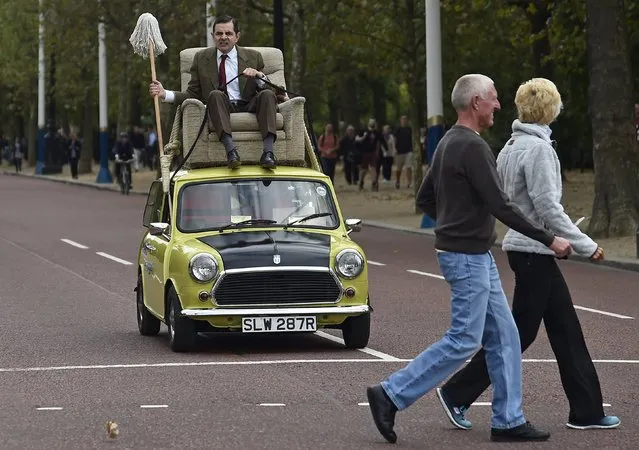 British comedian Rowan Atkinson, in character as “Mr Bean”, rides on a Mini car along The Mall in central London, September 4, 2015. He was promoting the television and film comedy character Mr Bean. (Photo by Toby Melville/Reuters)