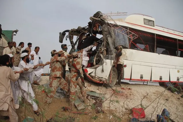 Rescue workers and soldiers recover the bodies of passengers who were killed when their bus collided with a truck near Jamshoro, Pakistan, 02 August 2016. At least 12 passengers were killed while 25 injured when a passenger bus from Dera Ismail Khan, enroute to Karachi, collided with a truck near Jamshoro. Fatal traffic accidents are common in Pakistan with most of them said to be caused by reckless driving and poor road conditions. (Photo by Nadeem Khawer/EPA)