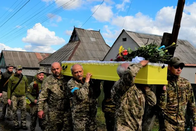 Soldiers carry the coffin of their comrade, Ukrainian military officer Volodumur Linsky, who was killed in a battle against Russian troops, in Kramatorsk, Ukraine, Saturday, September 24, 2022. (Photo by Andriy Andriyenko/AP Photo)