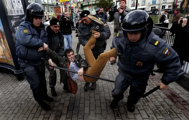 Police officers detain political activist Roman Dobrokhotov during the unauthorized meeting to mark Russian President Vladimir Putin's 60th birthday in Moscow, on October 7, 2012. (Photo by Sergey Ponomarev/Associated Press)