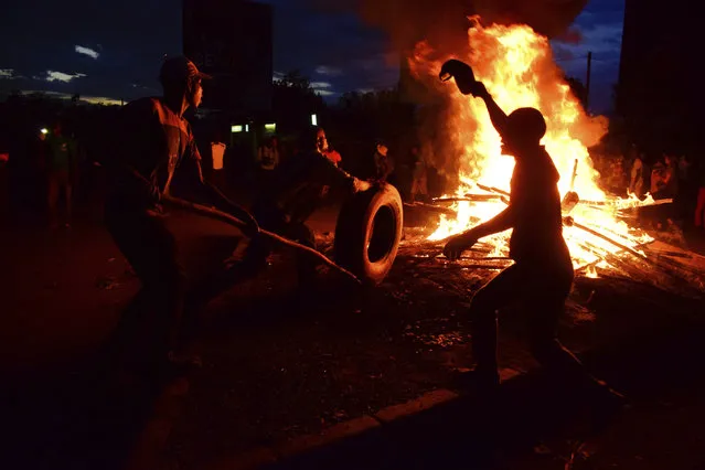 Residents demonstrate as they burn tires in the street  after the election result was announced, in Kisumu, Kenya, Monday, October 30, 2017. Clashes erupted after Kenya's election commission said President Uhuru Kenyatta had won the election that was boycotted by the main opposition group. (Photo by AP Photo/Stringer)