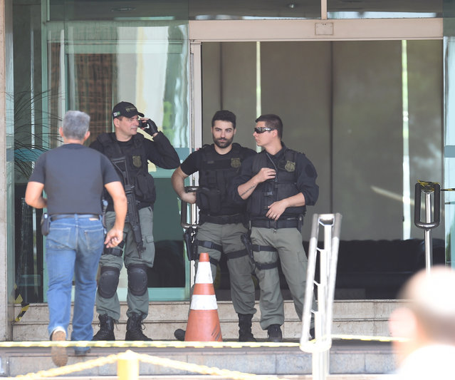 Police special forces are deployed at a hotel where an unidentified man keeps a hotel employee with an explosive-laden vest at a balcony of the hotel in Brasilia on September 29, 2014. (Photo by Evaristo Sa/AFP Photo)