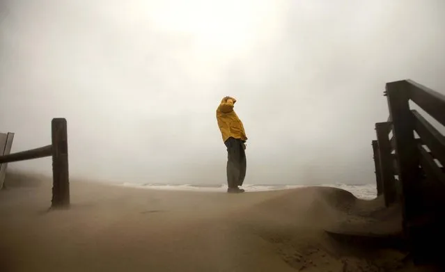 Matt Francis holds onto his hat as the wind-driven sand and rain from Hurricane Sandy blows across the beaches of Sandbridge in Virginia Beach. (Photo by L. Todd Spencer/The Virginian-Pilot)