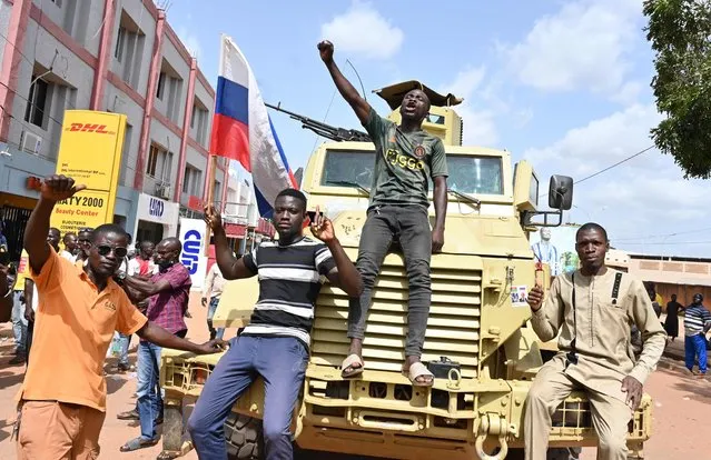 Protesters demonstrate agaisnt France and the Economic Community of West African States (ECOWAS) whose representatives are expected today in Ouagadougou on October 4, 2022. Several dozen protestors waving Russian flags rallied in Burkina Faso's capital Ouagadougou on Tuesday as West African envoys arrived on a fact-finding mission following the country's second coup in less than nine months. (Photo by Issouf Sanogo/AFP Photo)