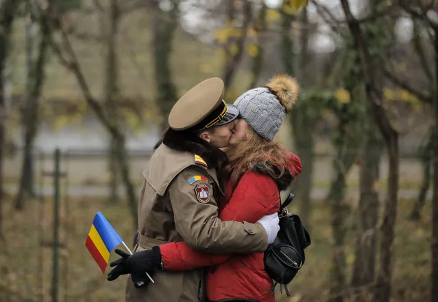A soldier kisses a girl before the start of Romania's national day military parade in Bucharest, Romania, Friday, December 1, 2017. (Photo by Vadim Ghirda/AP Photo)