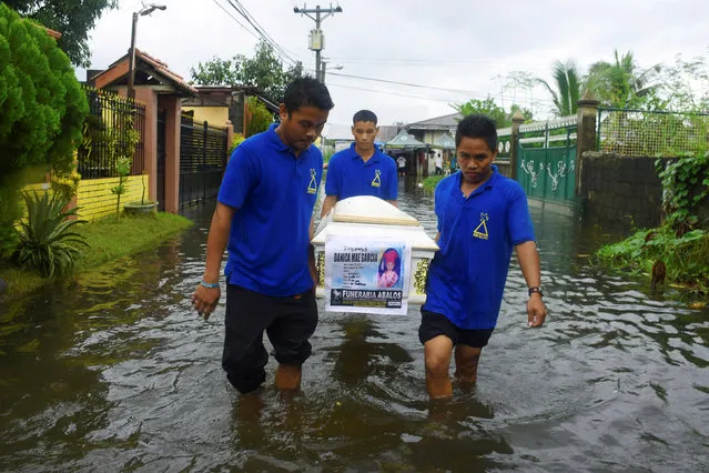 Funeral employees wade in floodwaters while carrying the coffin of Danica Mae Garcia during her funeral rites at a local cemetery in Dagupan City, north of Manila, Philippines August 31, 2016. Garcia, 5, was killed at home by an unidentified gunman who police said was targeting Garcia's grandfather, Maximo Garcia, allegedly involved in drug trade. (Photo by Reuters/Stringer)