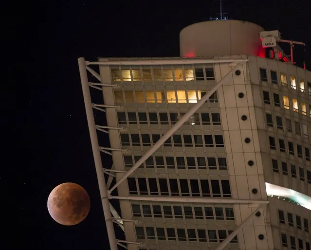 The supermoon appears behind the Turning Torso building during a total lunar eclipse in Malmo, south of Sweden September 28, 2015. (Photo by Johan Nilsson/Reuters/TT News Agency)