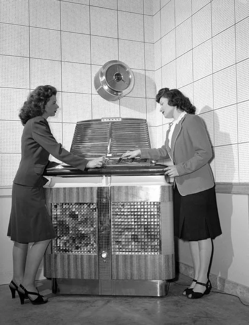 Vera Fidler, left, and Peddy Duffin of the office staff select a number on one of the new electronic phonographs just off the assembly line at the plant in Kansas City, Kansas, April 27, 1946. While on a rest period, the ladies act as testers for the new juke boxes. (Photo by AP Photo)