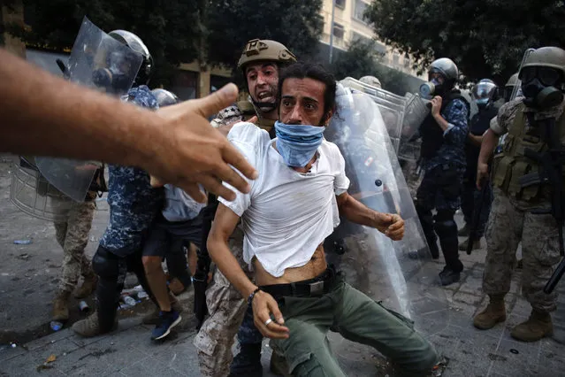 A protestor is evacuated from clashes during a protest against the political elites and the government after this week's deadly explosion at Beirut port which devastated large parts of the capital in Beirut, Lebanon, Saturday, August 8, 2020. (Photo by Thibault Camus/AP Photo)