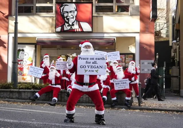 Animal rights activists of People for the Ethical Treatment of Animals (PETA), wearing Santa Claus costumes, hold placards reading “Peace on Earth for All. Go Vegan” in front of a KFC fast food restaurant in Tokyo, Japan, 08 December 2022. In a statement, PETA said it is protesting against the killing of millions of chickens during KFC's annual Christmas campaign and is urging the fast food chain to provide vegan options in its menu in Japan. (Photo by Franck Robichon/EPA/EFE)