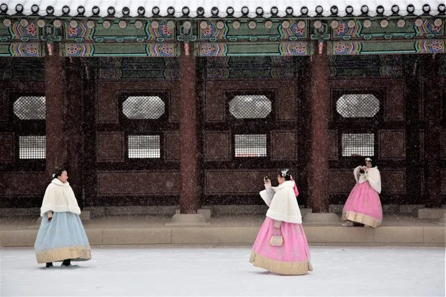 Vietnamese tourists wearing South Korean traditional clothes take a pictures in the snow during a visit to the Gyegbokgung Palace in Seoul South Korea, 15 December 2022. Korea Meteorological Administration (KMA) is forecasting heavy snow to hit the capital and central regions with the temperature in Seoul reaching minus 7.7 degrees Celsius. (Photo by Jeon Heon-Kyun/EPA/EFE)