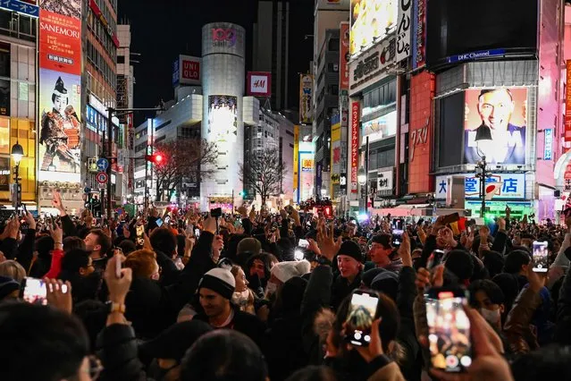 People celebrate the start of New Years Day at midnight in the Shibuya area of Tokyo early on January 1, 2023. (Photo by Richard A. Brooks/AFP Photo)