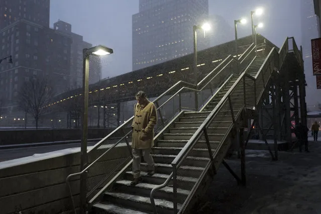 A man walks down a staircase through an early morning snowfall, Thursday, January 4, 2018, in New York. (Photo by Mark Lennihan/AP Photo)