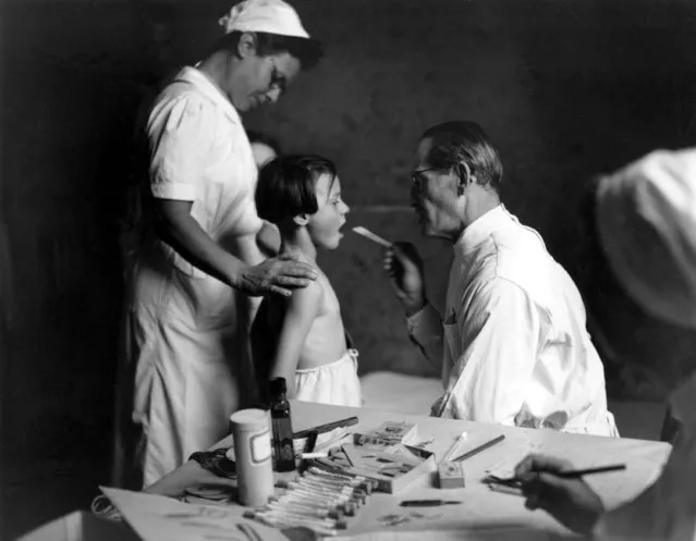 An orphan receives a medical examination in Geneva, Switzerland, on December 9, 1945 at the end of World War II.  As guests for a 90-day period, 60,000 young orphans of war-torn Europe are treated for skin infections and lice discovered during routine medical inspection in preparation for farming the children out to Swiss families. (Photo by AP Photo)