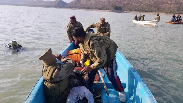 In this photo released by Inter Services Public Relations, army soldier head back after recovered a child body during search operation in Tanda Dam, in Kohat, a district of Pakistan's Khyber Pakhtunkhwa province, Tuesday, January 31, 2023. The death toll from a boating accident in a lake in northwest Pakistan over the weekend reached 51, the military said Tuesday. The vessel was carrying children and teachers from a seminary on a picnic. (Photo by Inter Services Public Relations via AP Photo)
